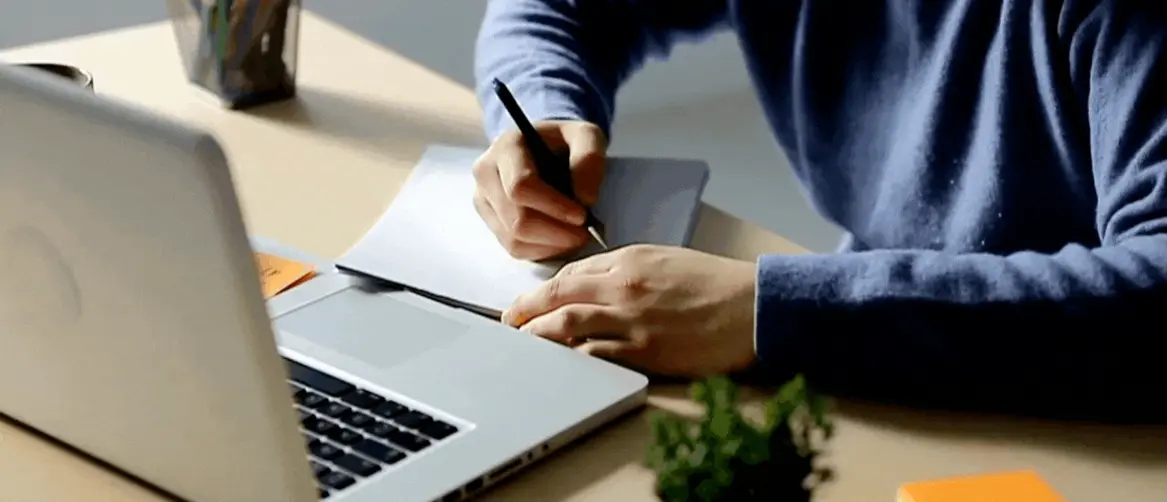 Vođenje bilješki pred otvorenim računalom