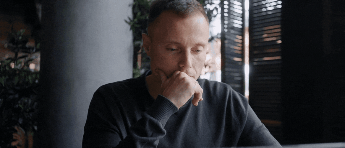 Muškarac koji sjedi za stolom i razmišlja