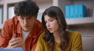 Muškarac i žena nad kompjuterom kako traže rješenje