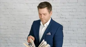 Intelektualac koji lista knjigu i razmišlja