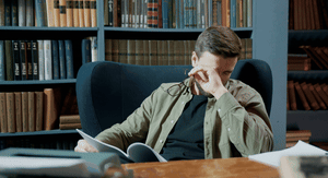 Skidanje naočala u knjižnici i trljanje očiju