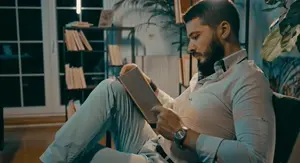 Muškarac na kauču kako čita knjigu