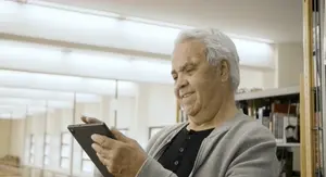 Starac na tabletu koji rješava kviz znanja