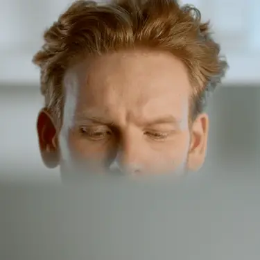 Muškarac koji gleda na laptop i razmišlja