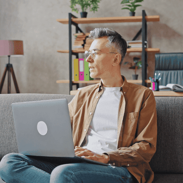 Sjedenje na kauču i igranje na laptopu