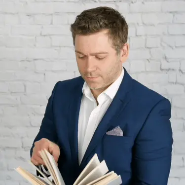 Intelektualac koji lista knjigu i razmišlja