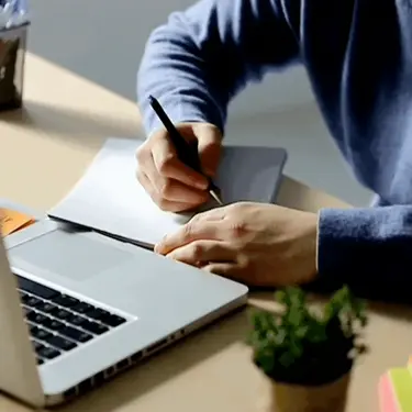 Vođenje bilješki pred otvorenim računalom