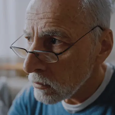 Starac koji razmišlja i gleda u kameru