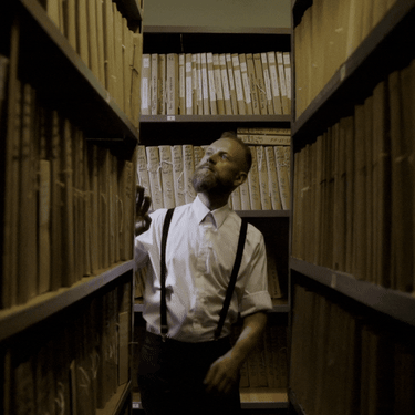 Muškarac koji bira knjigu u knjižnici