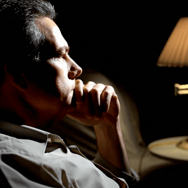 Muškarac koji razmišlja u slabo osvijetljenoj sobi