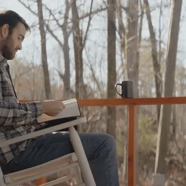 Čitanje knjige na terasi i razmišljanje