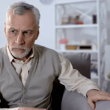 Starac koji sjedi u fotelji i razmišlja