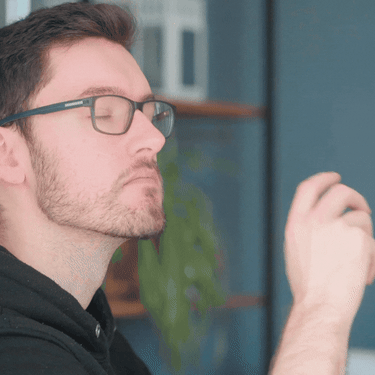 Muškarac s naočalama koji gleda u daljinu i razmišlja