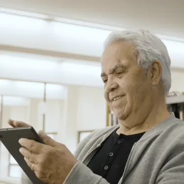 Starac na tabletu koji rješava kviz znanja