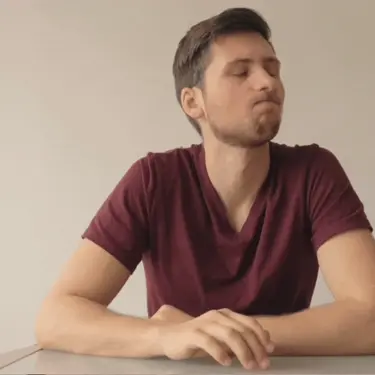 Muškarac koji nervozno lupka po stolu dok razmišlja