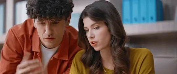 Muškarac i žena nad kompjuterom kako traže rješenje