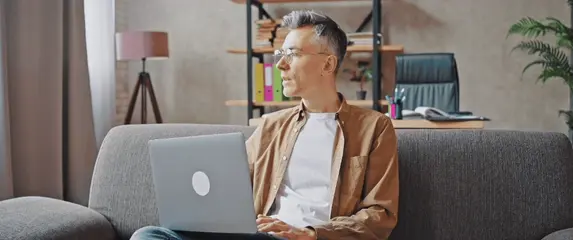 Sjedenje na kauču i igranje na laptopu