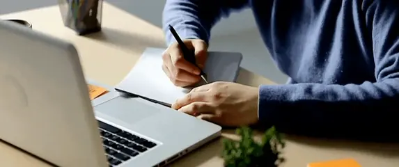 Vođenje bilješki pred otvorenim računalom