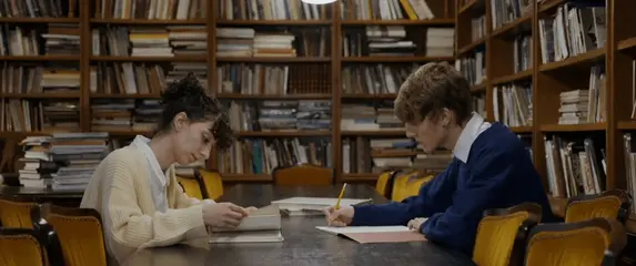 Studenti u knjižnici kako uče i čitaju