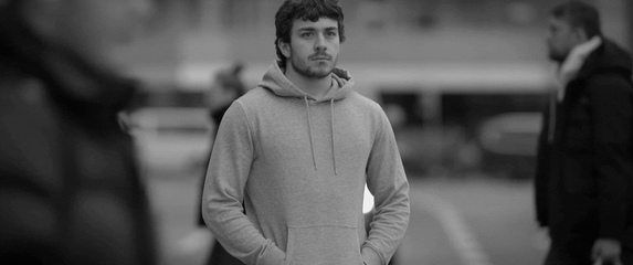 Muškarac koji razmišlja dok kraj njega prolaze ljudi