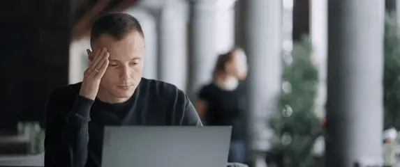 Razmišljanje za stolom pred laptopom