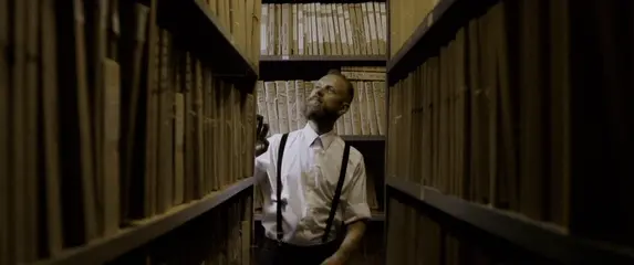 Muškarac koji bira knjigu u knjižnici