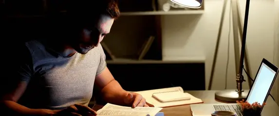 Razmišljanje pred knjigom za stolom