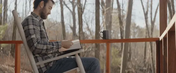 Čitanje knjige na terasi i razmišljanje