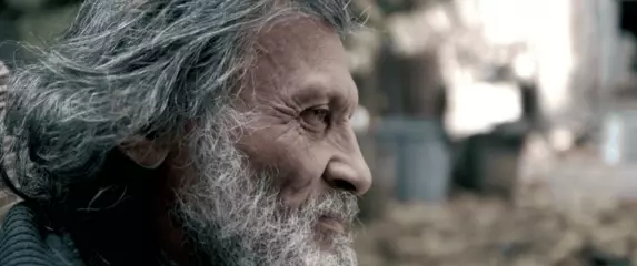 Mudri stariji muškarac koji se okreće prema kameri