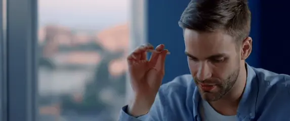 Muškarac koji razmišlja za stolom s olovkom u ruci