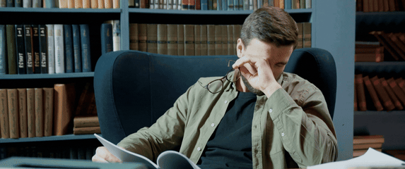 Skidanje naočala u knjižnici i trljanje očiju