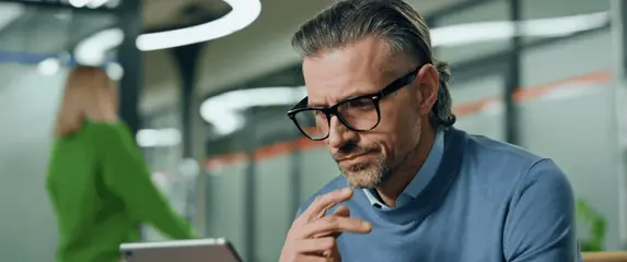 Muškarac koji razmišlja u uredu za radnim stolom