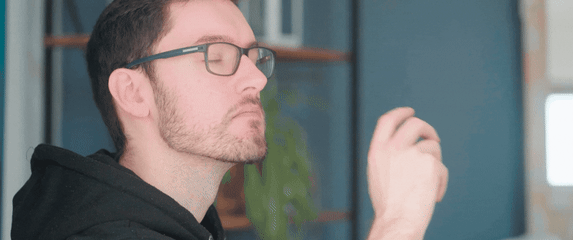 Muškarac s naočalama koji gleda u daljinu i razmišlja