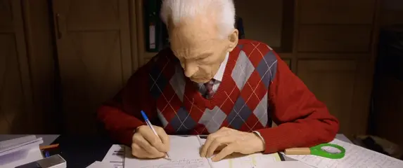 Stariji muškarac koji piše pismo