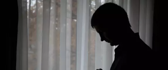 Muškarac koji razmišlja i rješava kviz na mobitelu