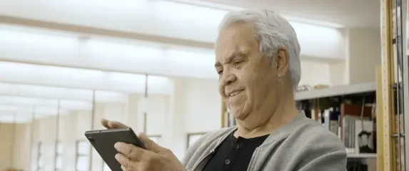 Starac na tabletu koji rješava kviz znanja