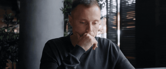 Muškarac koji sjedi za stolom i razmišlja