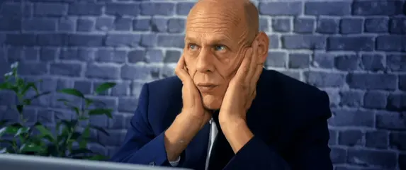 Stariji čovjek koji razmišlja pred računalom