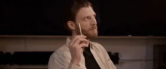 Muškarac kako razmišlja s olovkom u ruci