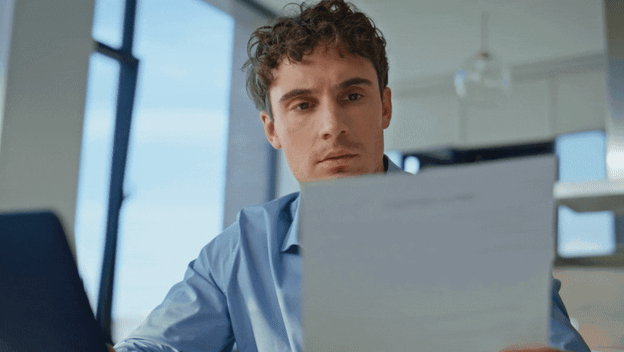 Muškarac koji čita i razmišlja s kemijskom u ustima