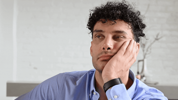 Sjedenje na kauču i držanje lica pri razmišljanju