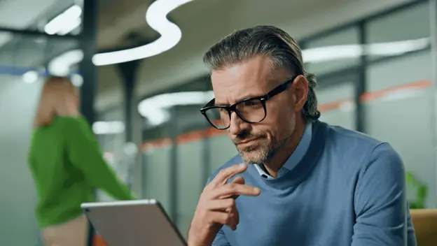 Muškarac koji razmišlja u uredu za radnim stolom