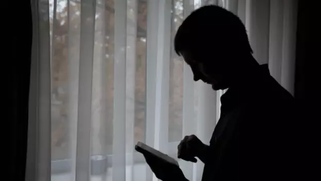 Muškarac koji razmišlja i rješava kviz na mobitelu