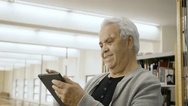 Starac na tabletu koji rješava kviz znanja