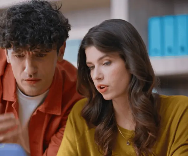 Muškarac i žena nad kompjuterom kako traže rješenje