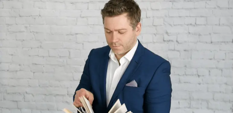 Intelektualac koji lista knjigu i razmišlja