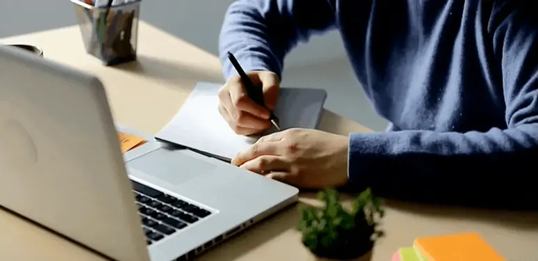 Vođenje bilješki pred otvorenim računalom