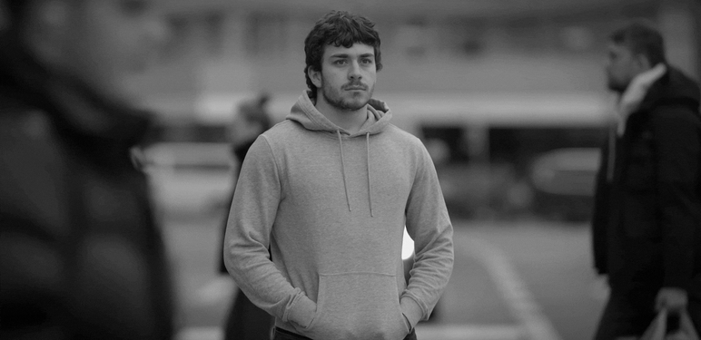 Muškarac koji razmišlja dok kraj njega prolaze ljudi