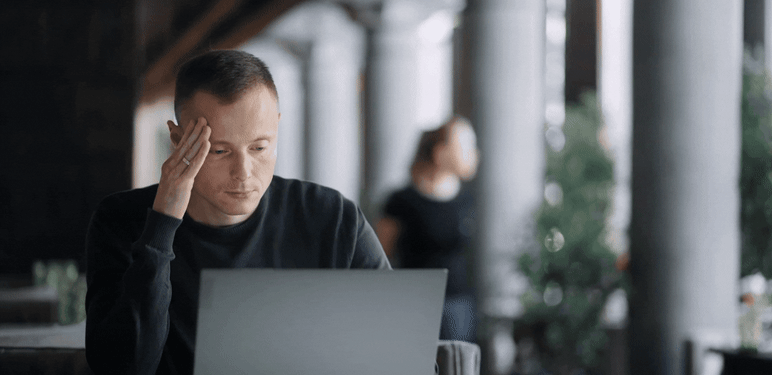 Razmišljanje za stolom pred laptopom