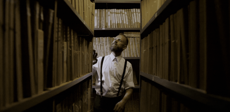 Muškarac koji bira knjigu u knjižnici